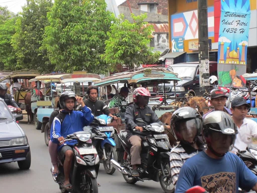 Scooters et cidomos dans la rue principale d'Ampenan, à Mataram