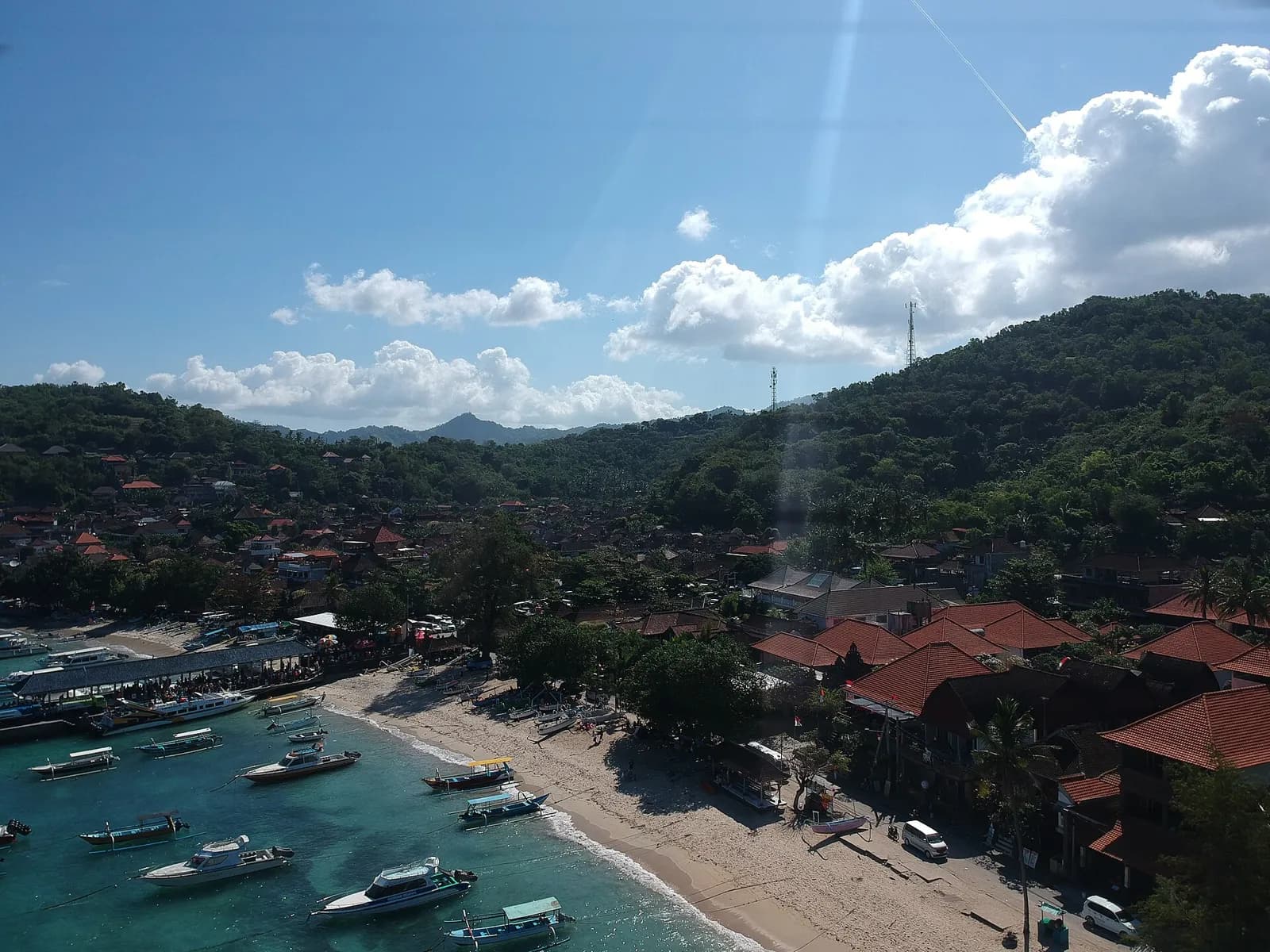 Le port de Padang Bai vu de haut, avec les bateaux dans la baie et les collines de l'est de Bali