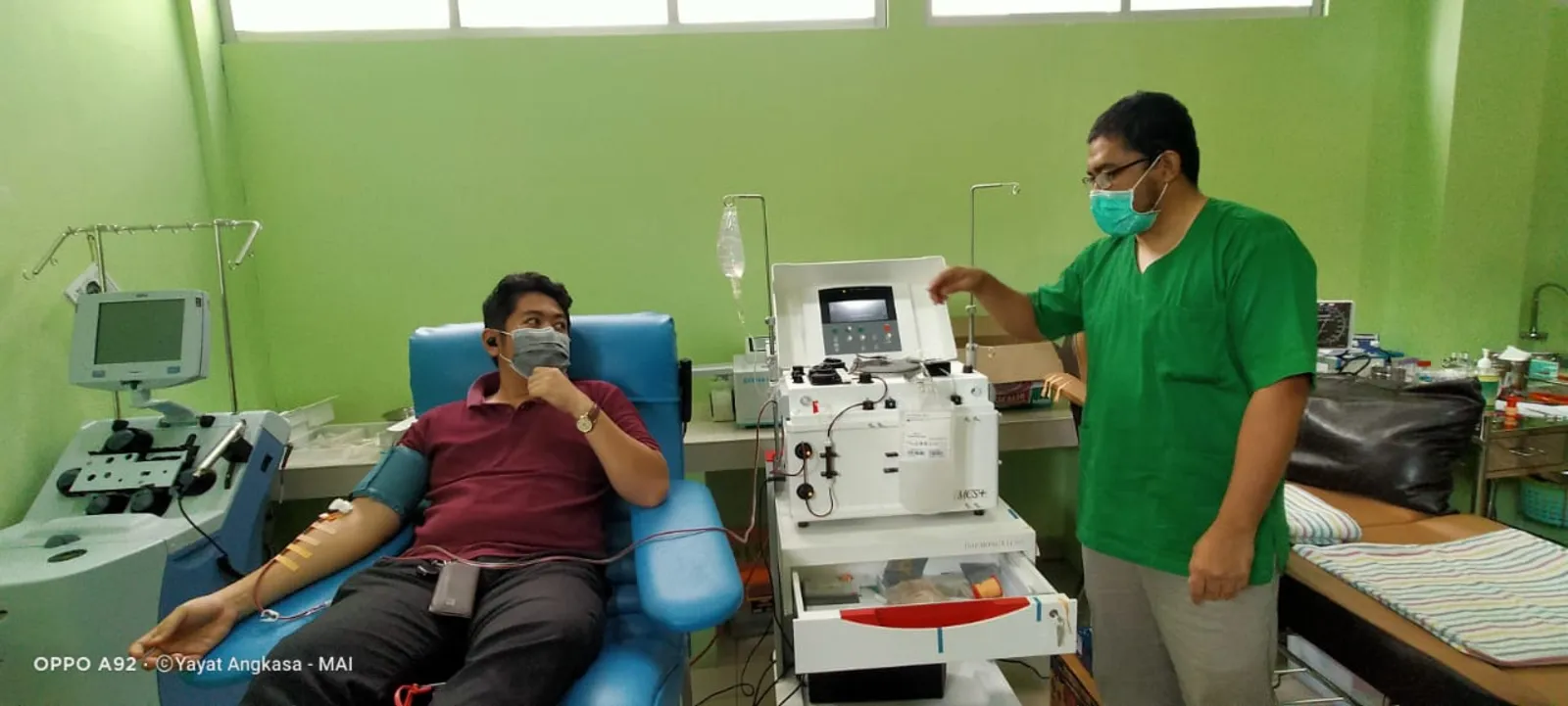 Un patient et un médecin devant un appareil médical dans une salle de l'hôpital RSUD NTB, à Mataram