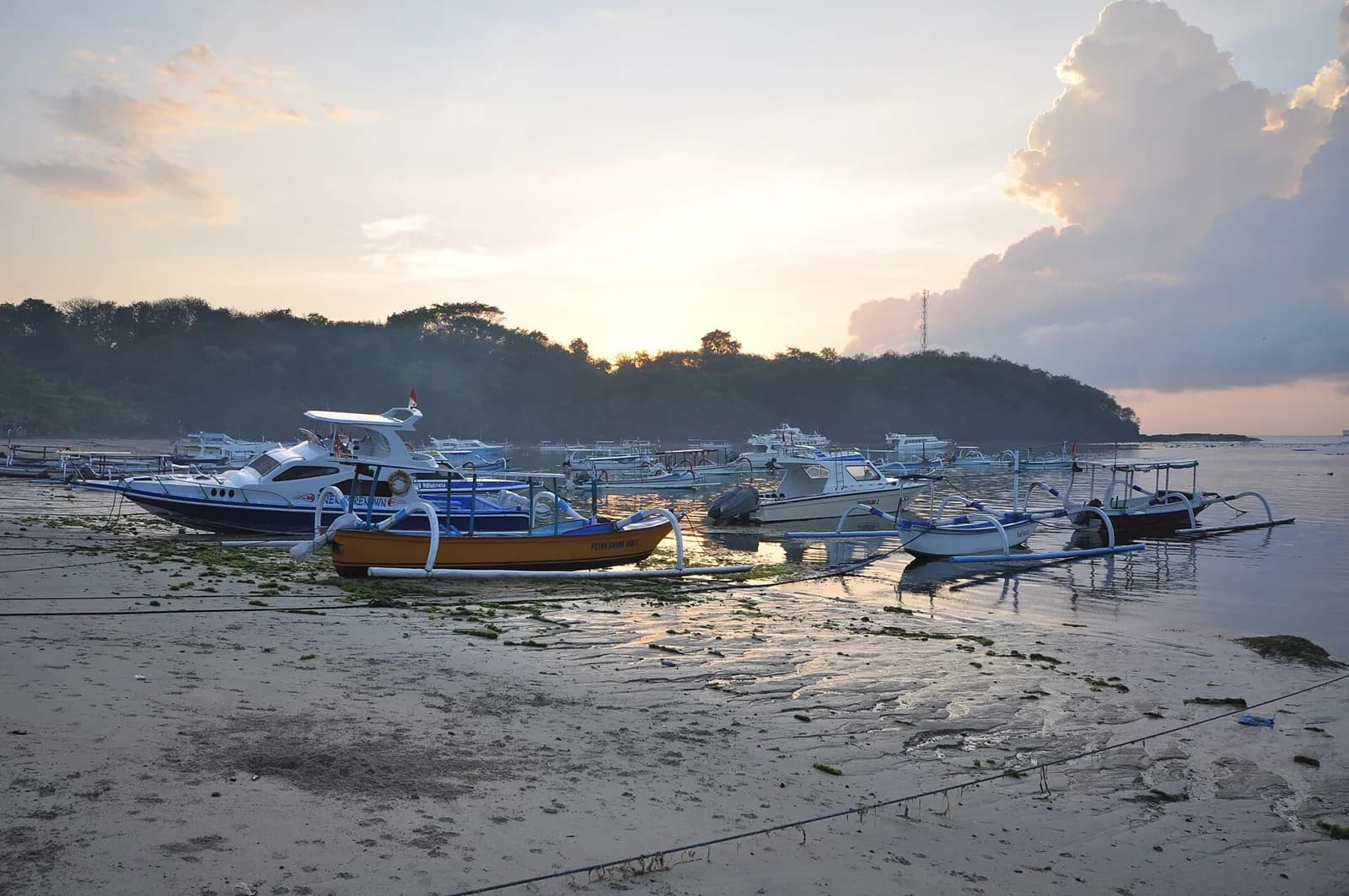 Bateaux de pêche et speed-boats sur la plage de Padang Bai, sur la côte est de Bali, au lever du jour