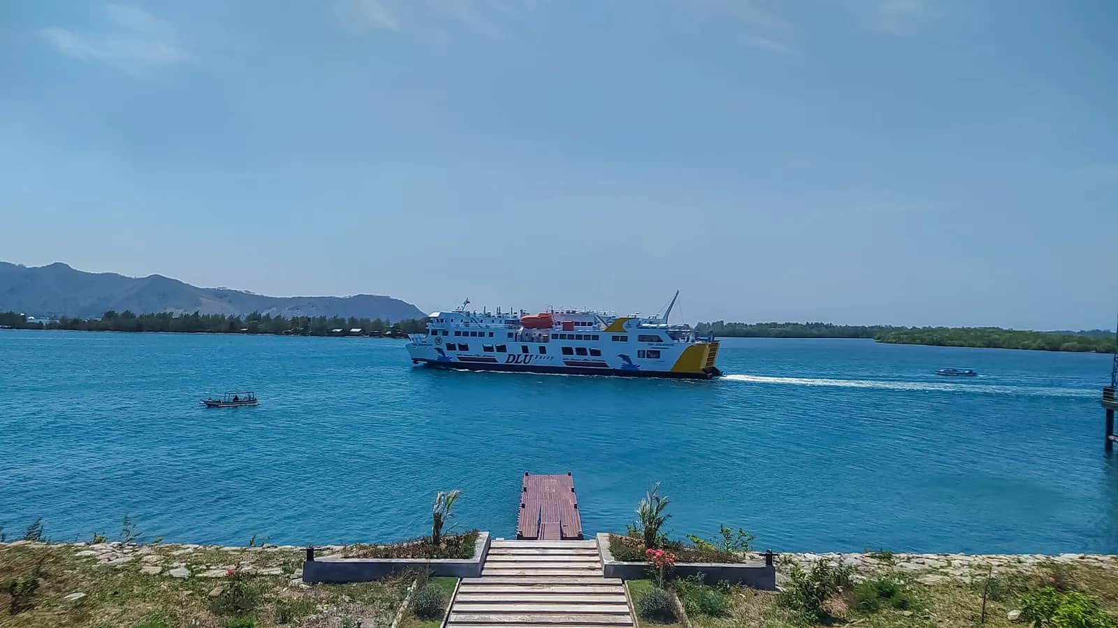 Ferry blanc et rouge quittant le port de Lembar, sur la côte ouest de Lombok, par mer calme