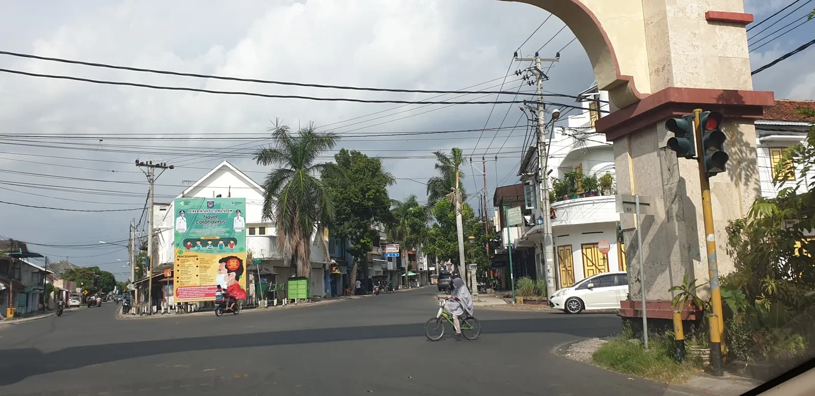 Carrefour de la vieille ville d'Ampenan, à Mataram, avec une arche, un feu tricolore et un cycliste