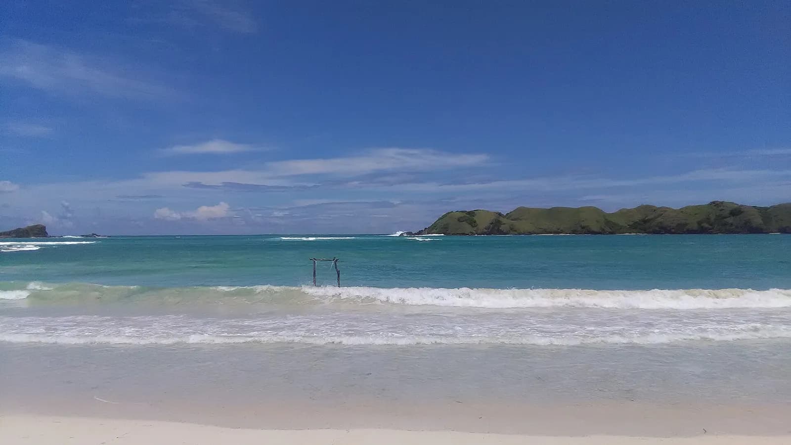 Plage de sable blanc de Tanjung Aan, dans le sud de Lombok, avec la mer turquoise et les collines de la baie