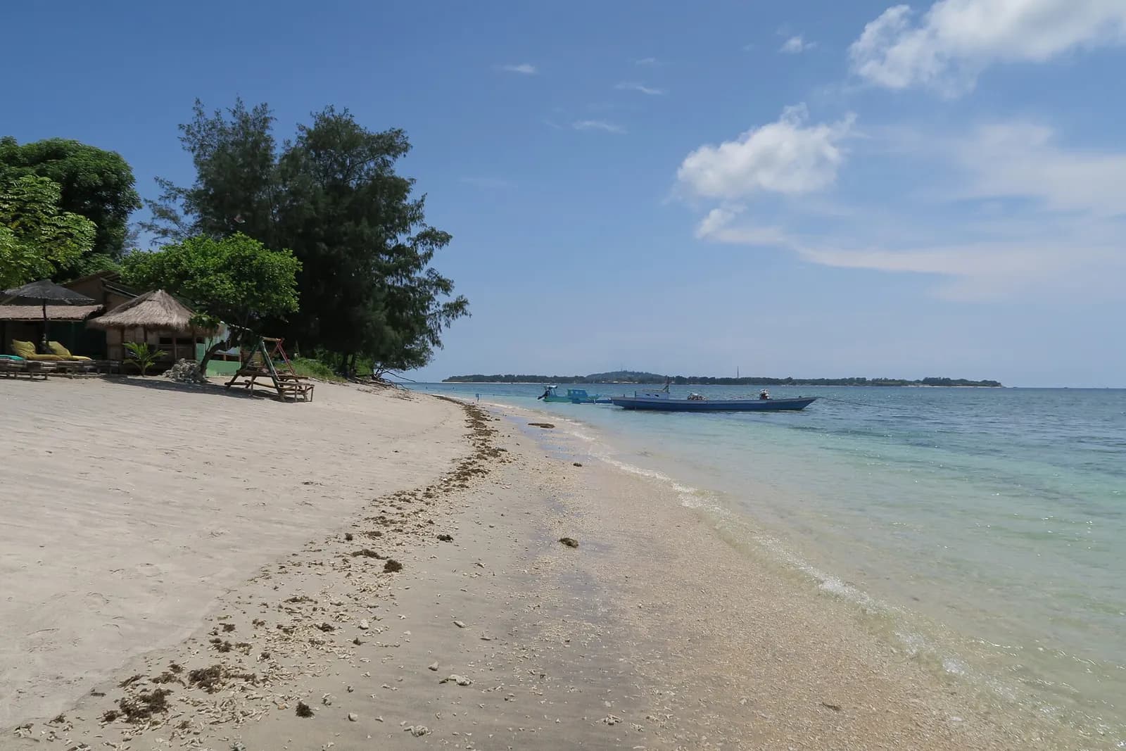 Plage de sable clair de la côte ouest de Gili Air, avec Gili Meno à l'horizon