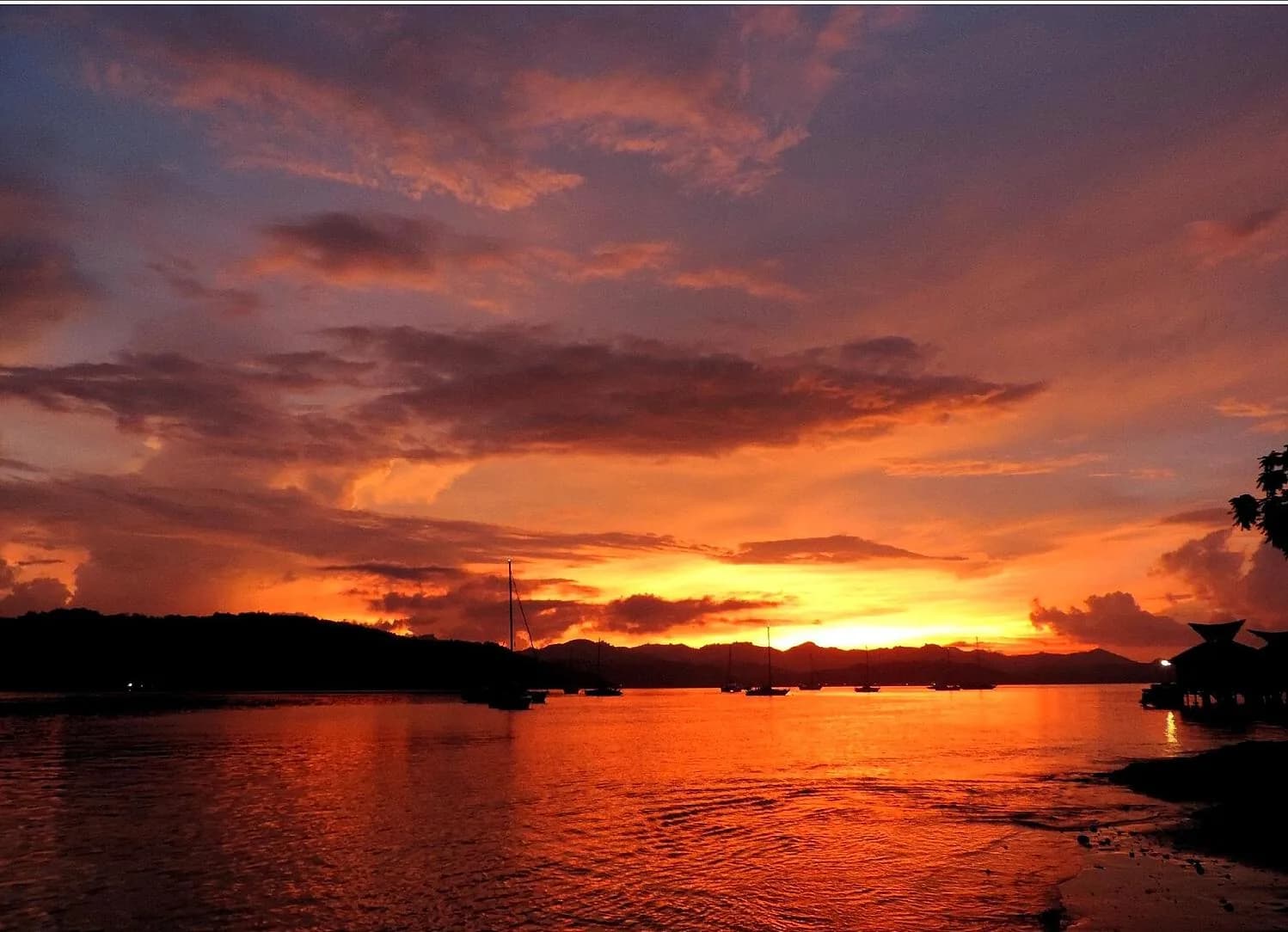 Coucher de soleil orangé sur la baie de Gili Gede, voiliers au mouillage, sud-ouest de Lombok