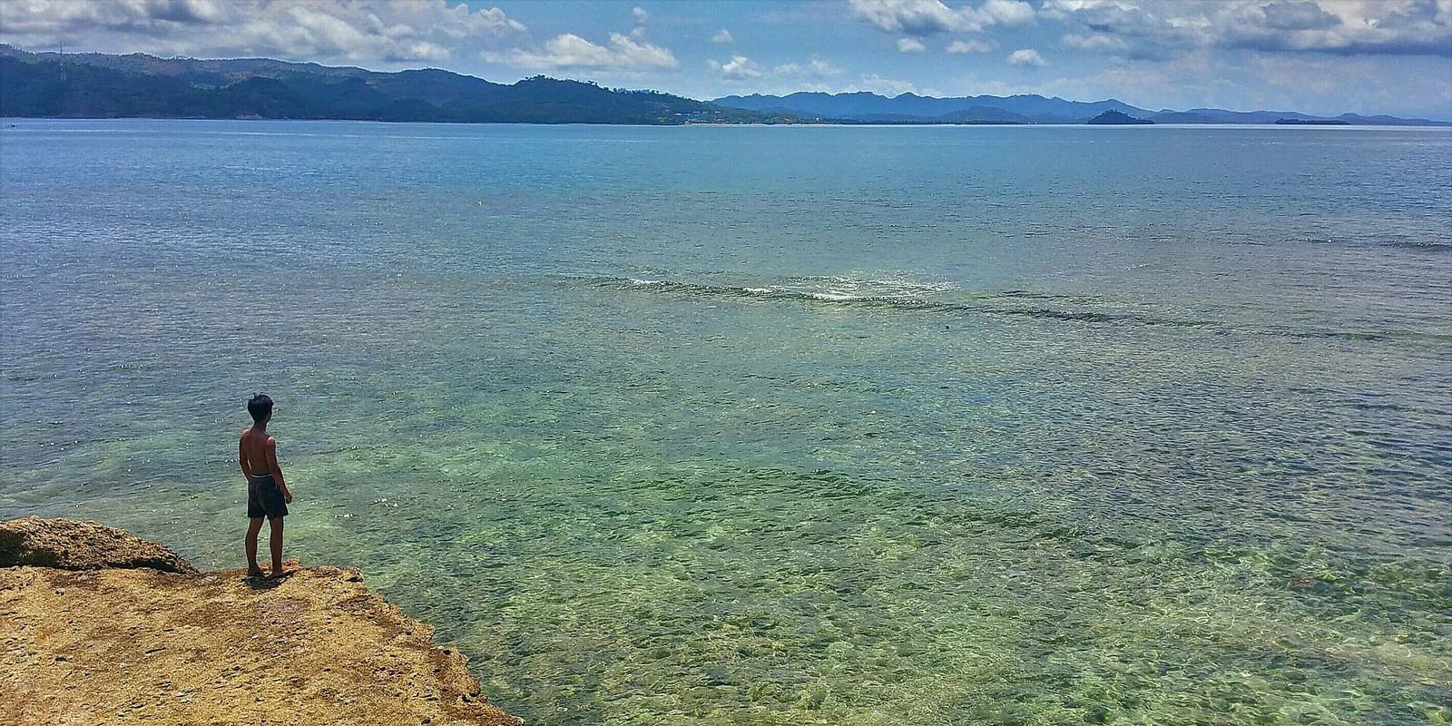Eaux claires et peu profondes au bord de Gili Nanggu, l'une des Secret Gilis de Sekotong, avec la côte de Lombok au fond