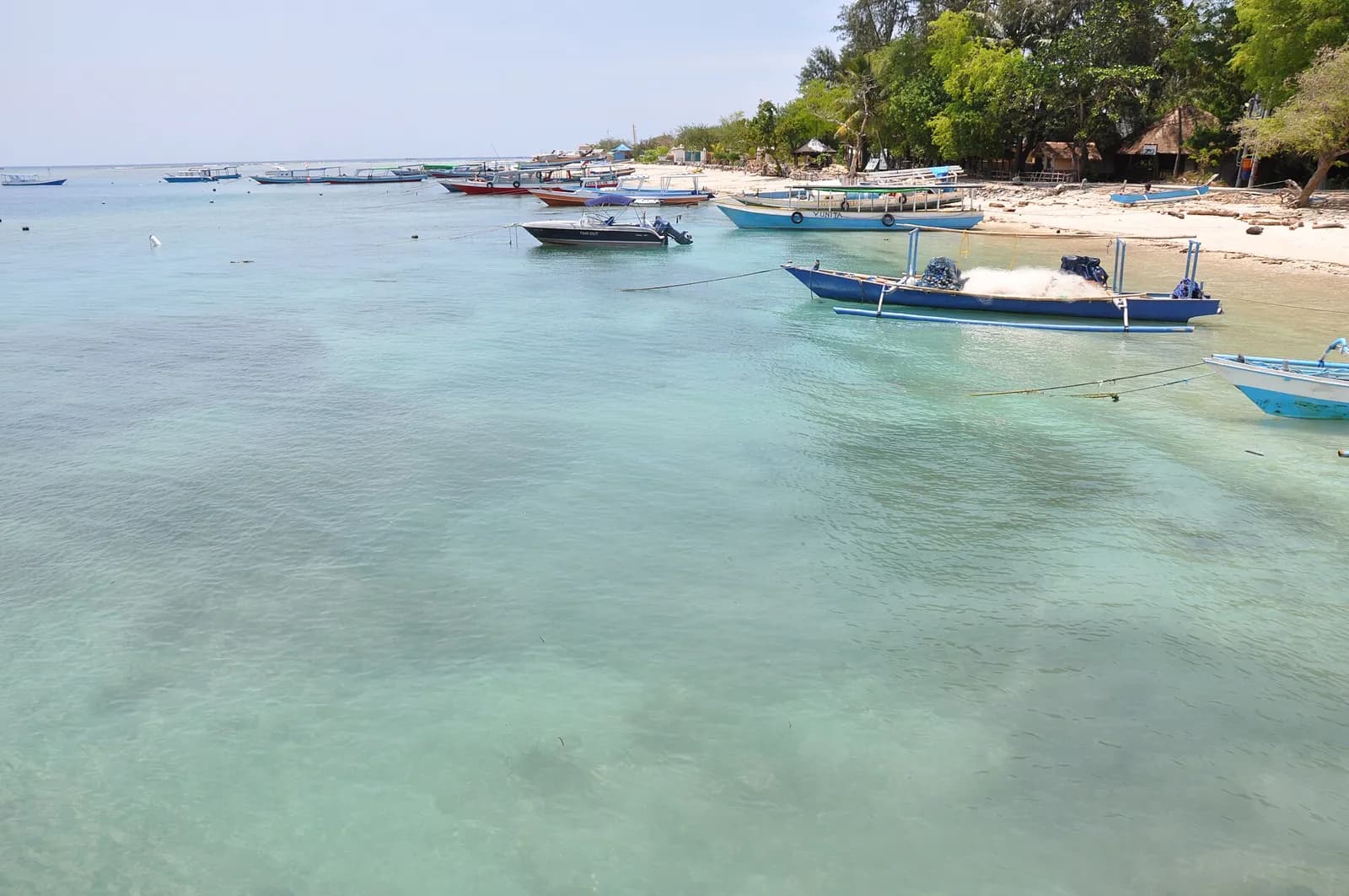 Bateaux traditionnels à balancier amarrés dans les eaux peu profondes d'une plage des îles Gili, au large de Lombok