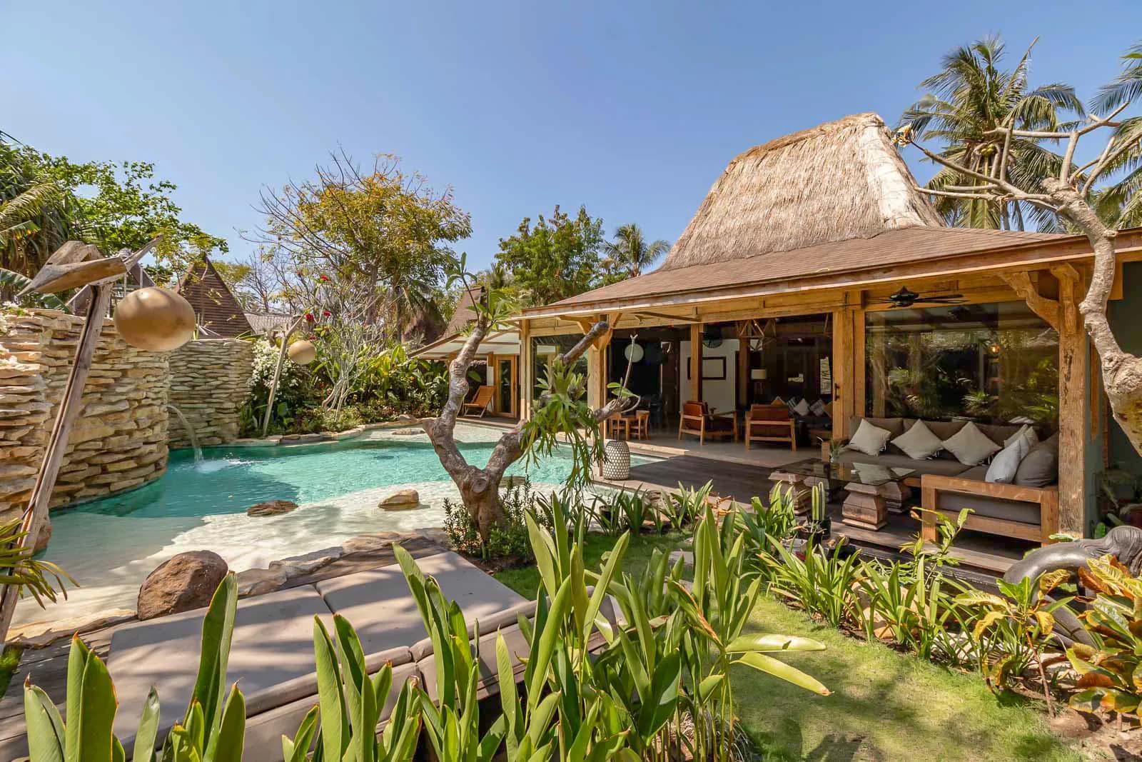 Villa en bois à toit de chaume avec piscine privée bordée de sable et de pierres, à Gili Trawangan