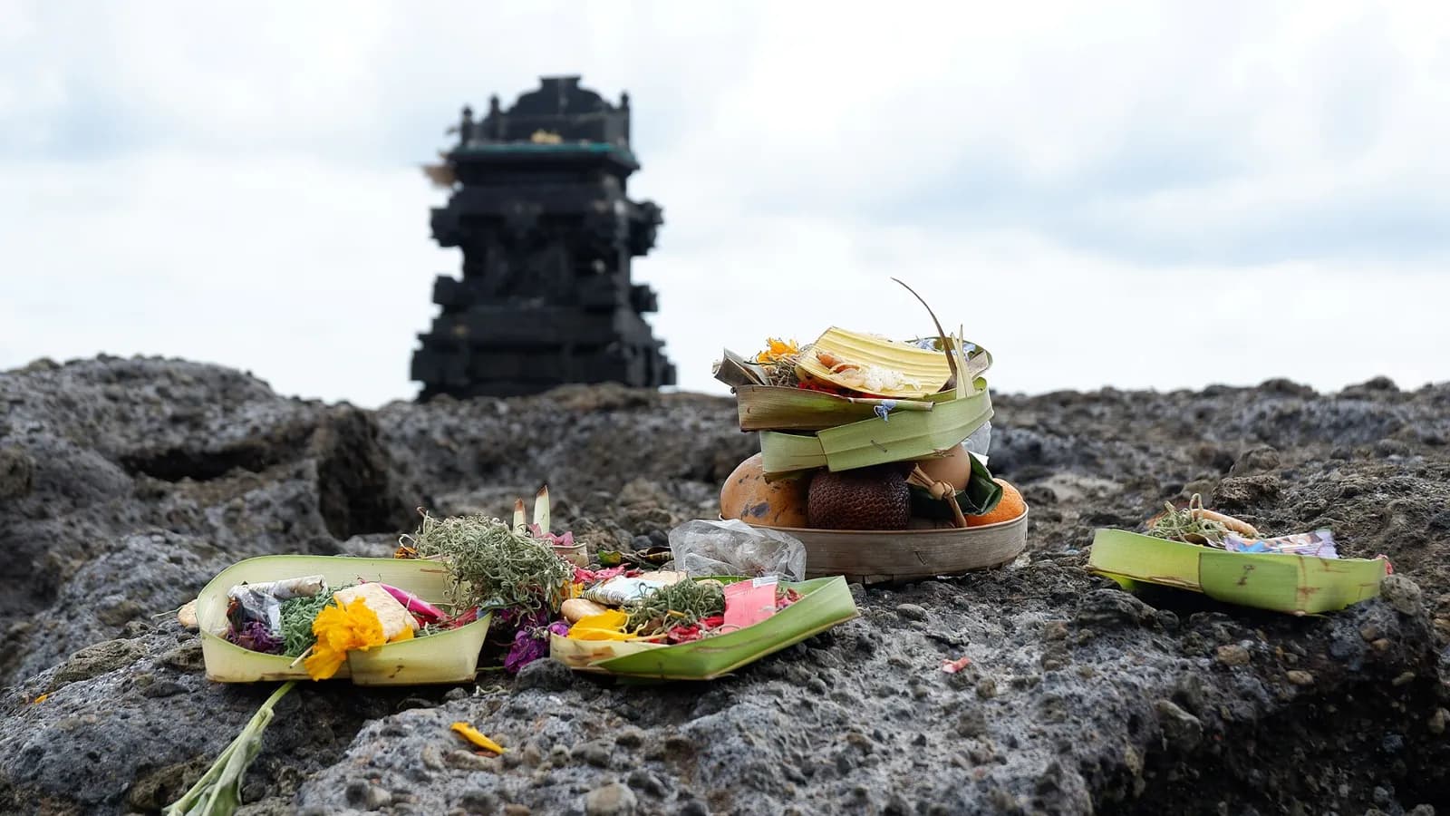 Offrandes de fleurs et de fruits déposées sur un rocher de la plage de Canggu, à Bali