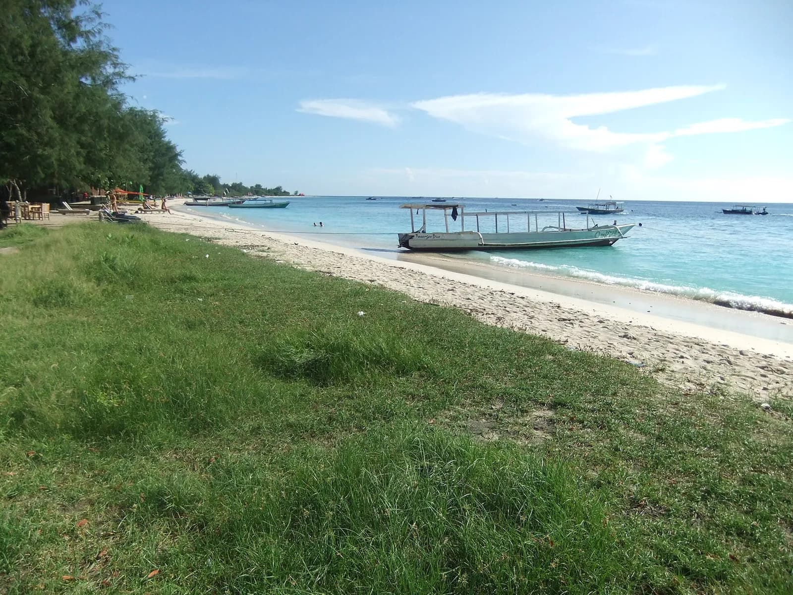 Plage de sable blanc et bateau en bois sur la mer turquoise à Gili Trawangan, au nord-ouest de Lombok