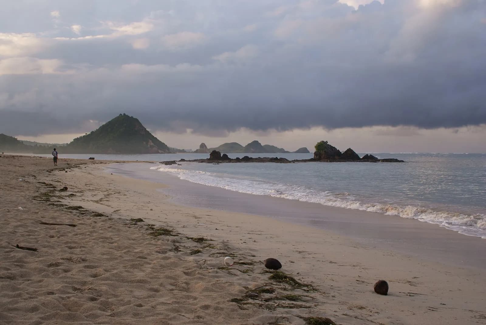 Plage de Kuta Lombok au crépuscule, avec la colline de Merese et des rochers au fond