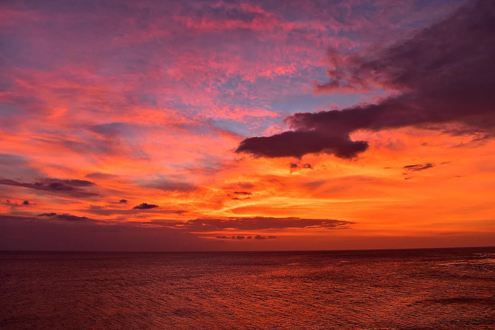 Ciel rouge et orange au coucher du soleil sur la mer, depuis la plage de Senggigi, côte ouest de Lombok