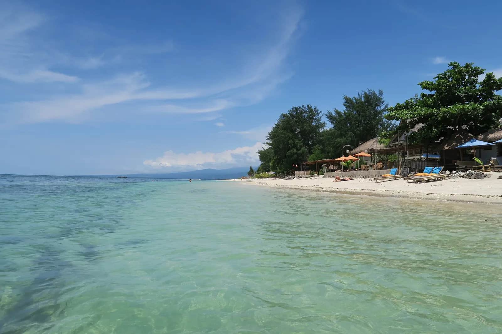 Plage de sable clair et eau turquoise peu profonde sur la côte ouest de Gili Air, face à Lombok
