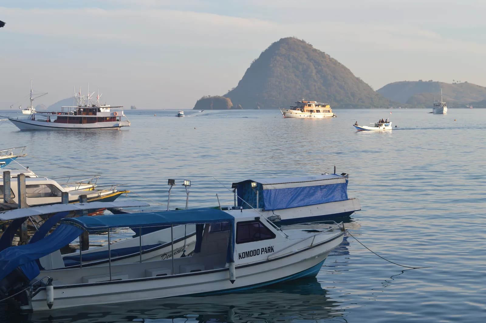 Bateaux amarrés près d'une île du parc national de Komodo au lever du soleil