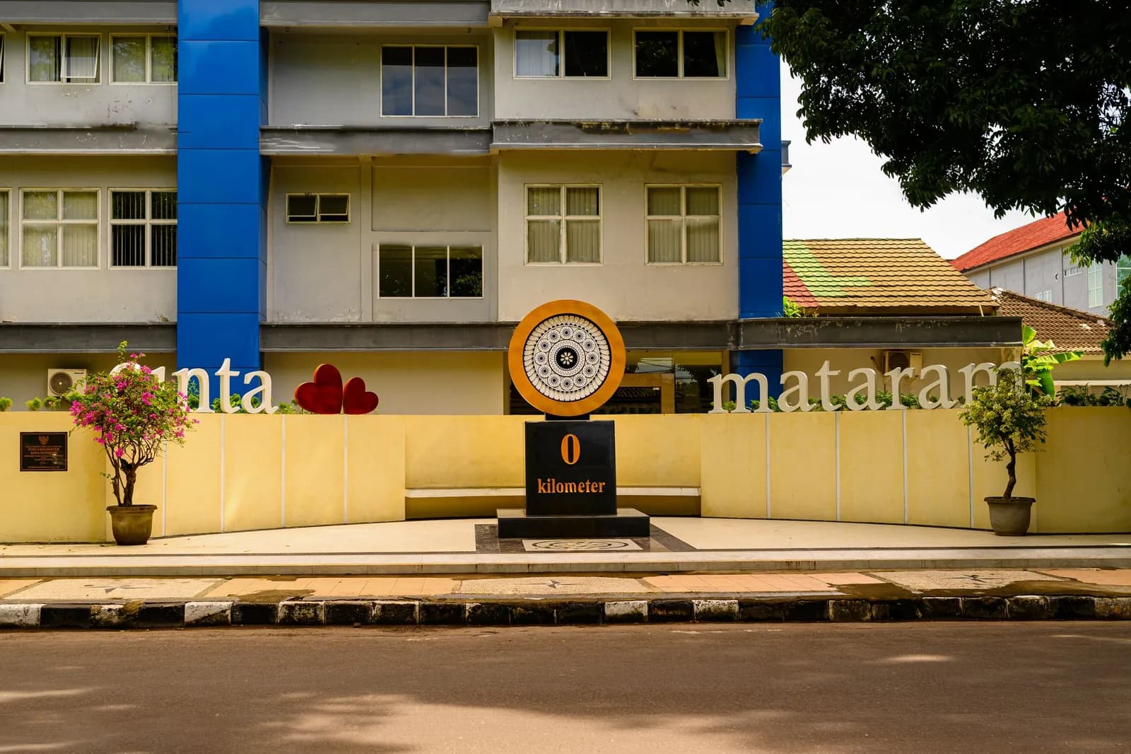 Monument et façades dans une rue de Mataram, Lombok