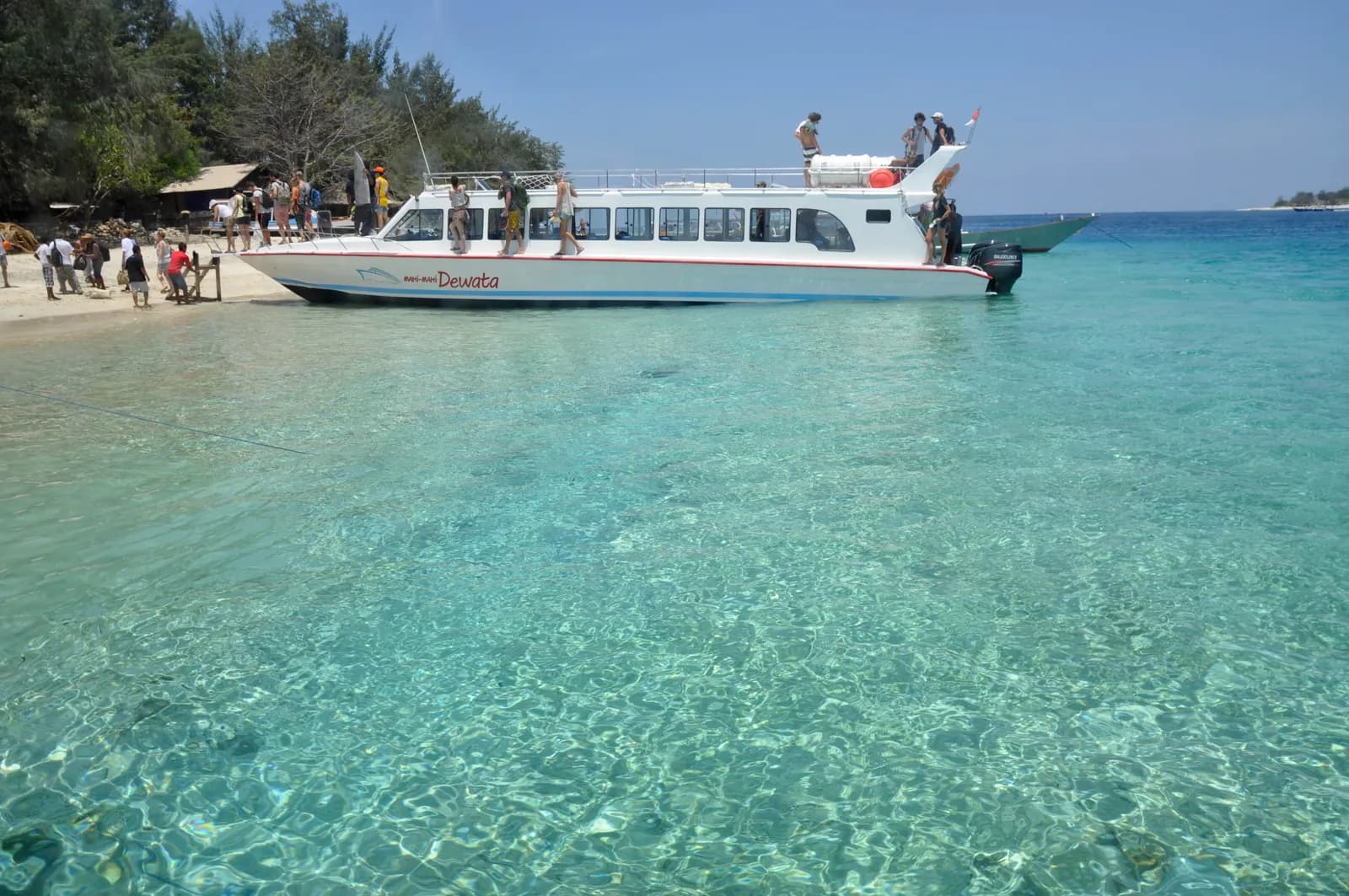 Bateau rapide échoué sur le sable devant une eau turquoise aux îles Gili