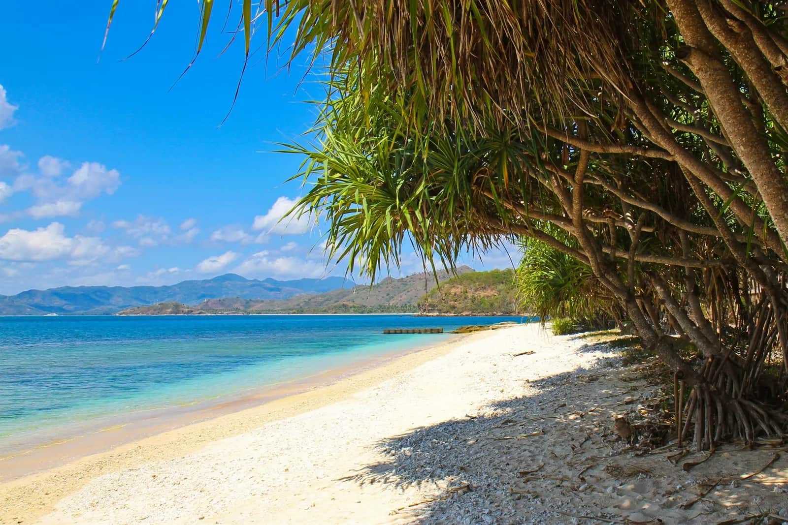 Plage de sable blanc de Gili Nanggu, au large de Sekotong, avec la côte de Lombok au fond