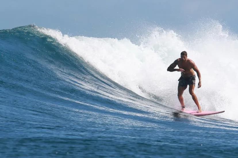 Surfeur sur la vague d'Outside Right, dans la baie de Gerupuk, à Lombok